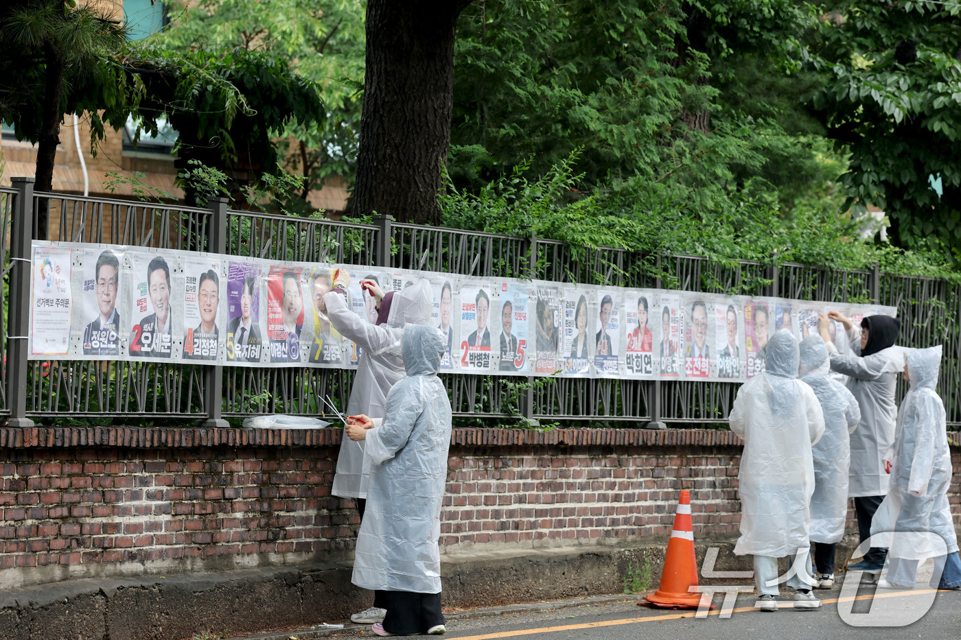 (서울=뉴스1) 이광호 기자 = 제9회 전국동시지방선거 공식 선거운동이 시작된 21일 오전 서울 종로구 예술가의 집 담장에 서울시선관위 직원들이 선거벽보를 첩부하고 있다. 2026 …