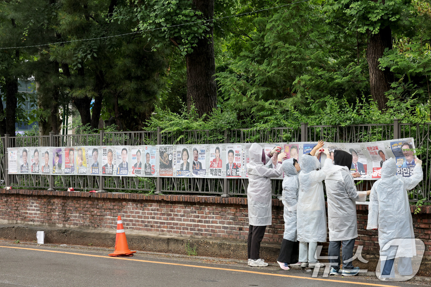 (서울=뉴스1) 이광호 기자 = 제9회 전국동시지방선거 공식 선거운동이 시작된 21일 오전 서울 종로구 예술가의 집 담장에 서울시선관위 직원들이 선거벽보를 첩부하고 있다. 2026 …