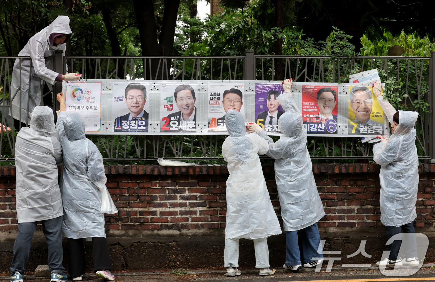 (서울=뉴스1) 이광호 기자 = 제9회 전국동시지방선거 공식 선거운동이 시작된 21일 오전 서울 종로구 예술가의 집 담장에 서울시선관위 직원들이 선거벽보를 첩부하고 있다. 2026 …