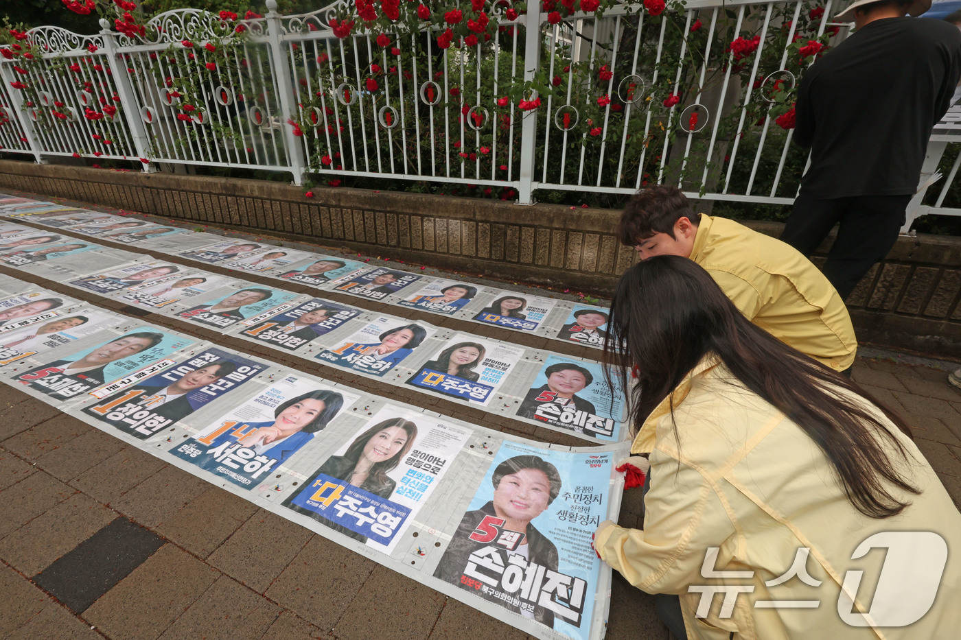 (광주=뉴스1) 박지현 기자 = 제9회 전국동시지방선거 공식 선거 운동 첫날인 21일 광주 북구 매곡동의 한 아파트에 광주 북구 관계자들이 선거벽보를 부착하고 있다. 2026.5. …