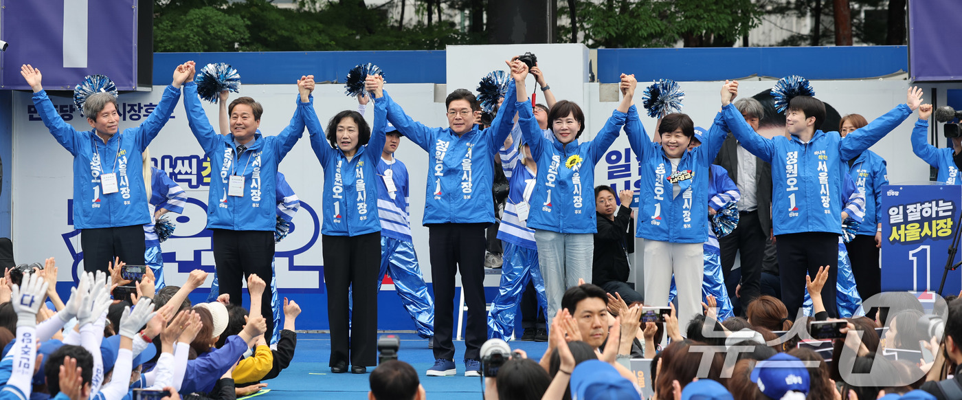 (서울=뉴스1) 박지혜 기자 = 정원오 더불어민주당 서울시장 후보가 21일 서울 성동구 왕십리역 광장에서 열린 출정식에서 배우자 문혜정 씨와 의원들의 손을 맞잡고 지지를 호소하고 …