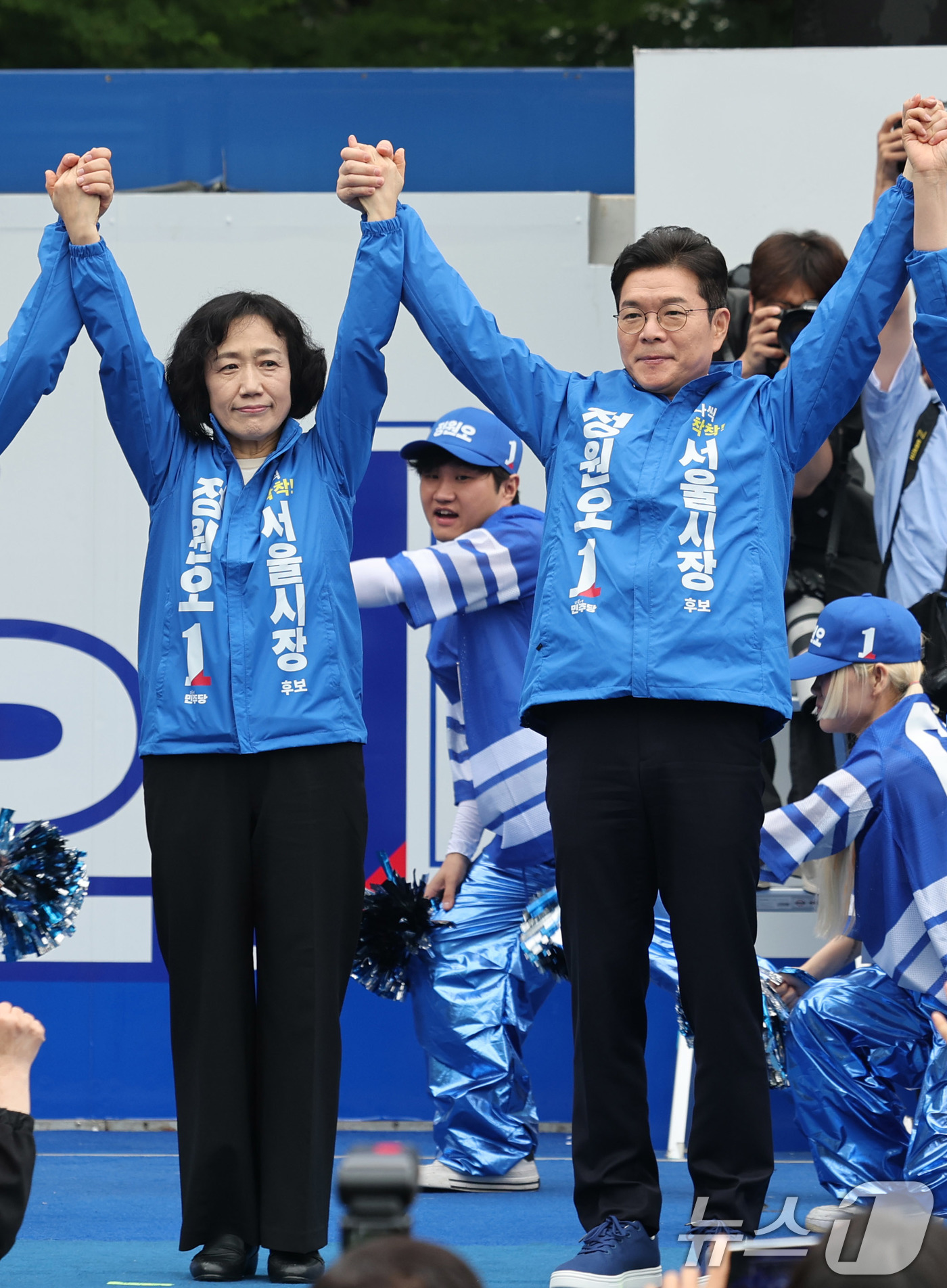 (서울=뉴스1) 박지혜 기자 = 정원오 더불어민주당 서울시장 후보가 21일 서울 성동구 왕십리역 광장에서 열린 출정식에서 배우자 문혜정 씨와 손을 맞잡고 지지를 호소하고 있다. 2 …