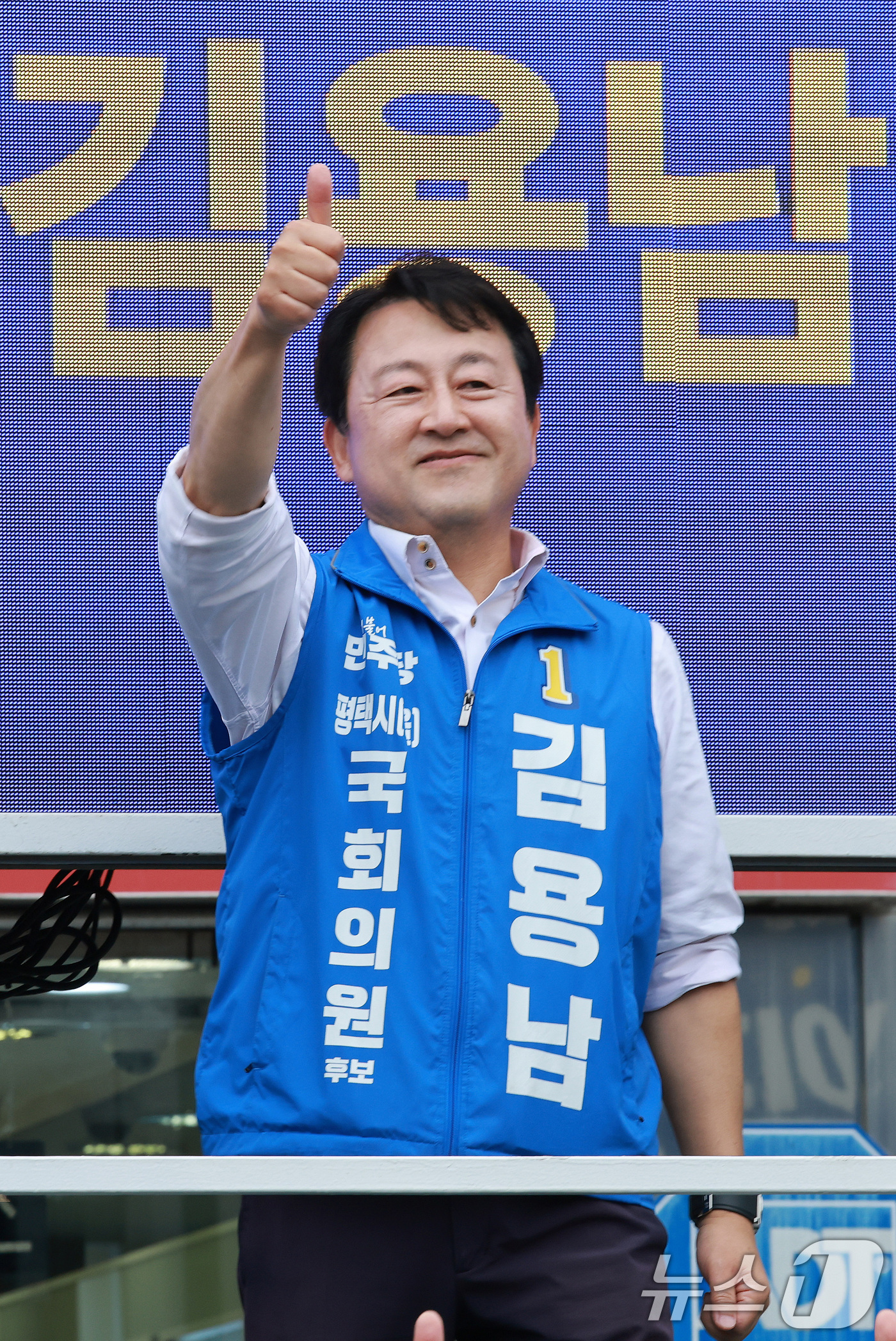 (평택=뉴스1) 임세영 기자 = 김용남 더불어민주당 경기평택을 국회의원 재선거 후보가 21일 경기도 평택시 안중시장 앞에서 열린 공식선거운동 출정식에서 엄지를 들어올리고 있다. 2 …