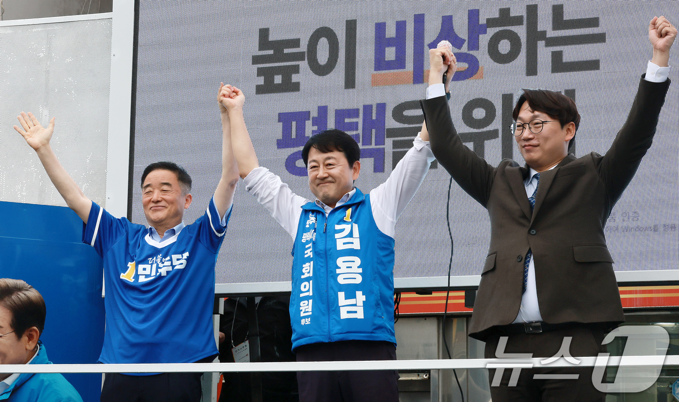 (평택=뉴스1) 임세영 기자 = 김용남 더불어민주당 경기평택을 국회의원 재선거 후보가 21일 경기도 평택시 안중시장 앞에서 열린 공식선거운동 출정식에서 손을 들어 올리고 있다. 왼 …