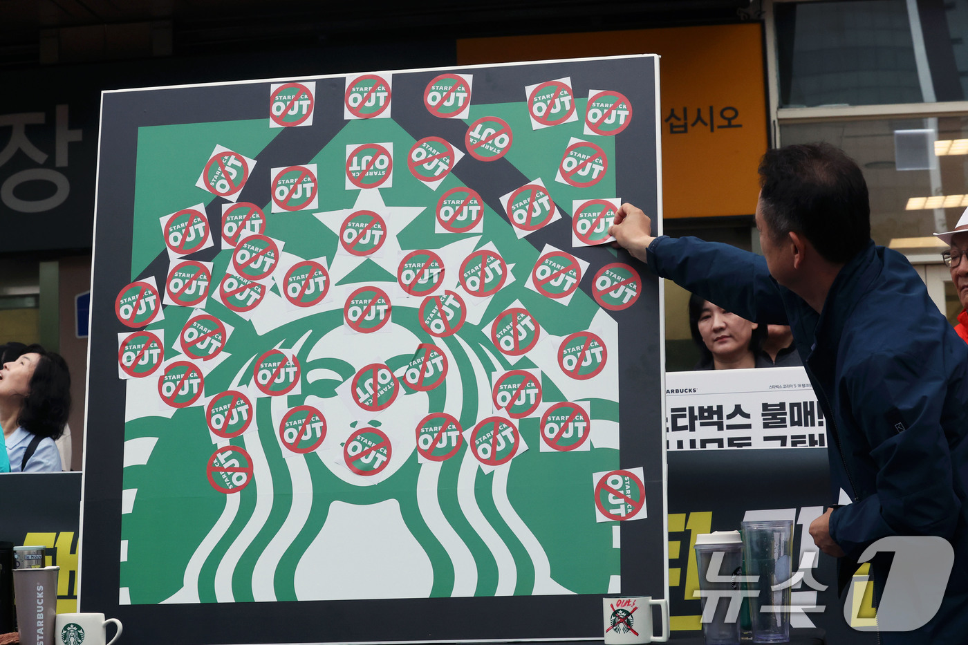 (광주=뉴스1) 조수민 수습기자 = 오월을 사랑하는 모임 등 광주시민단체 들이 21일 오후 광주 서구 광천동 이마트 광주점 앞에서 스타벅스의 '5·18 탱크데이' 마케팅을 규탄하는 …
