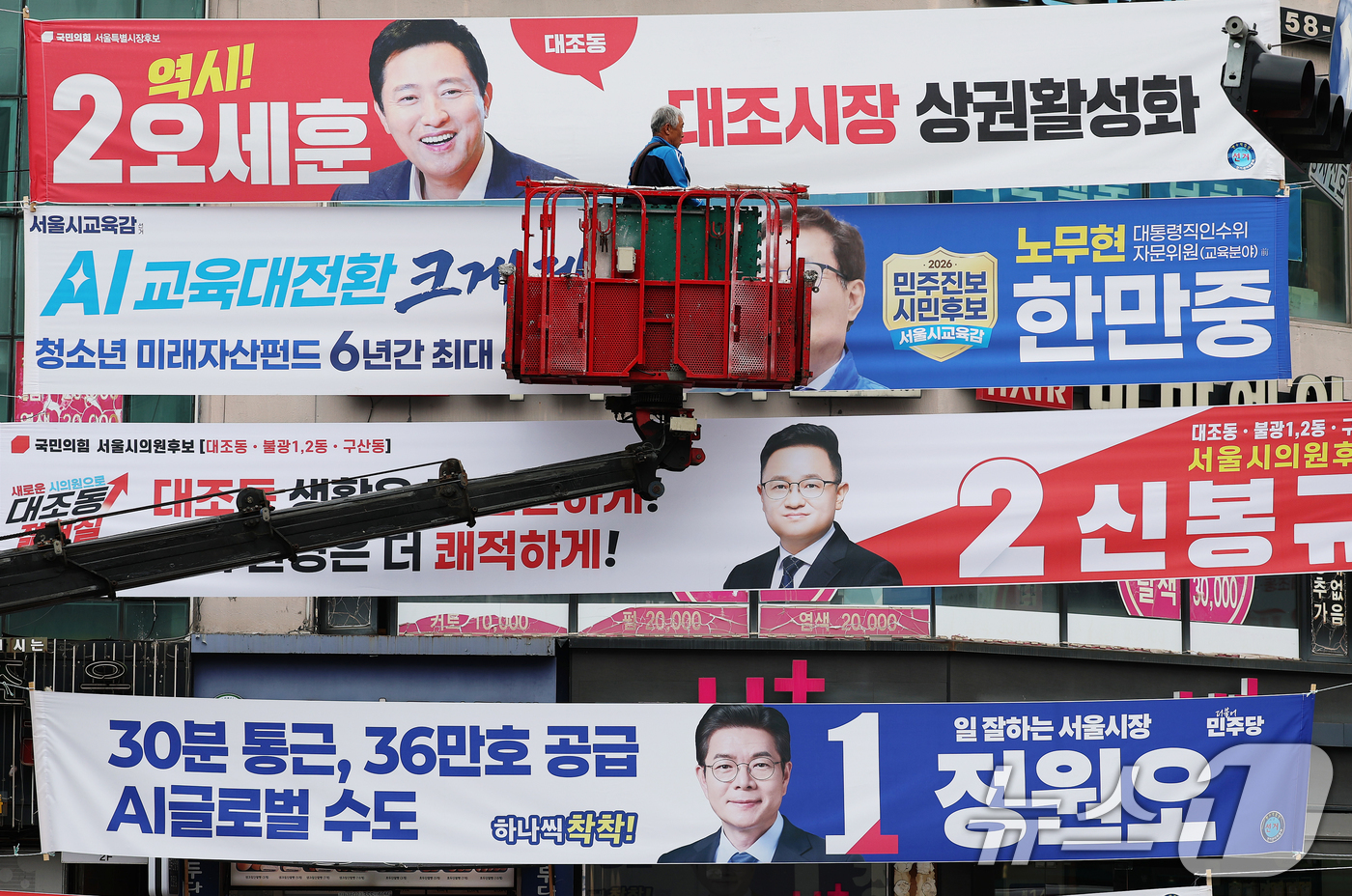 (서울=뉴스1) 오대일 기자 = 6·3 지방선거 공식 선거운동이 시작된 21일 서울 은평구의 한 거리에서 작업자가 각 정당 서울시장·서울시교육감 후보자들의 선거 현수막을 걸고 있다 …
