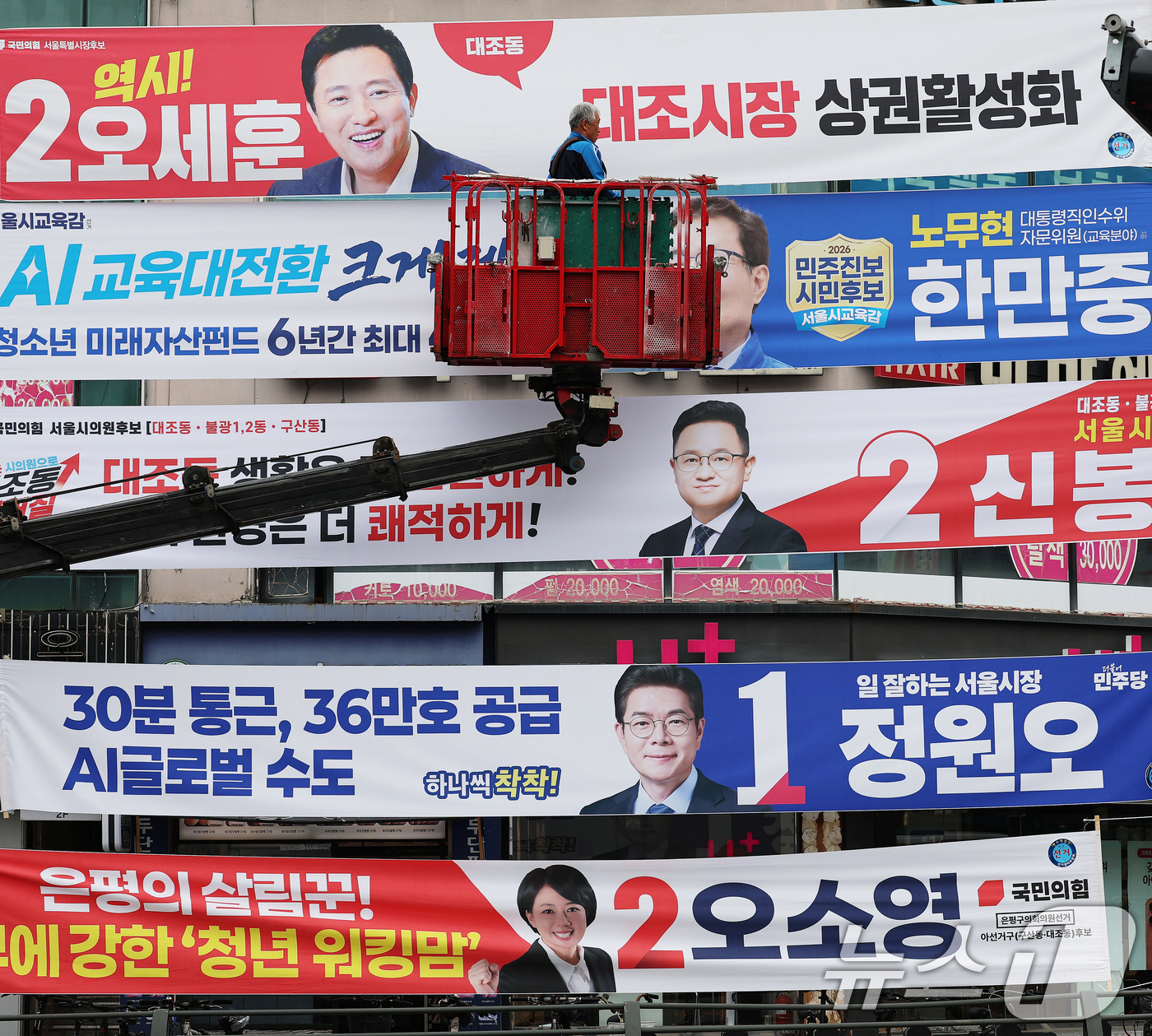 (서울=뉴스1) 오대일 기자 = 6·3 지방선거 공식 선거운동이 시작된 21일 서울 은평구의 한 거리에서 작업자가 각 정당 서울시장·서울시교육감 후보자들의 선거 현수막을 걸고 있다 …