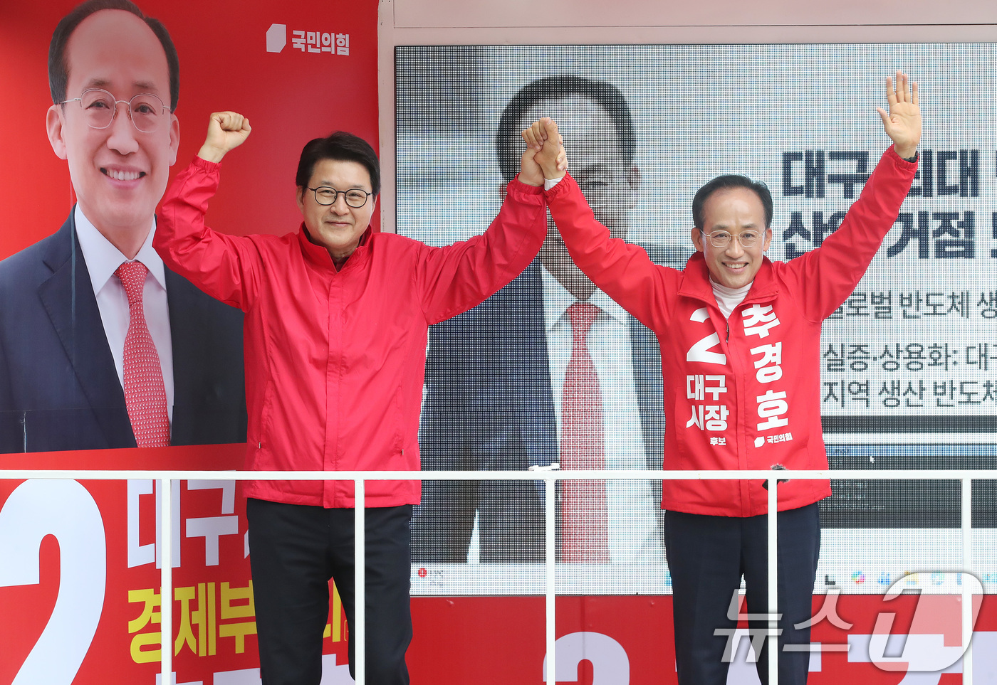(대구=뉴스1) 공정식 기자 = 추경호 국민의힘 대구시장 후보가 21일 오후 대구 중구 현대백화점 앞에서 열린 국민의힘 지방선거 출정식에서 신동욱 최고위원과 손을 들어올리고 있다. …