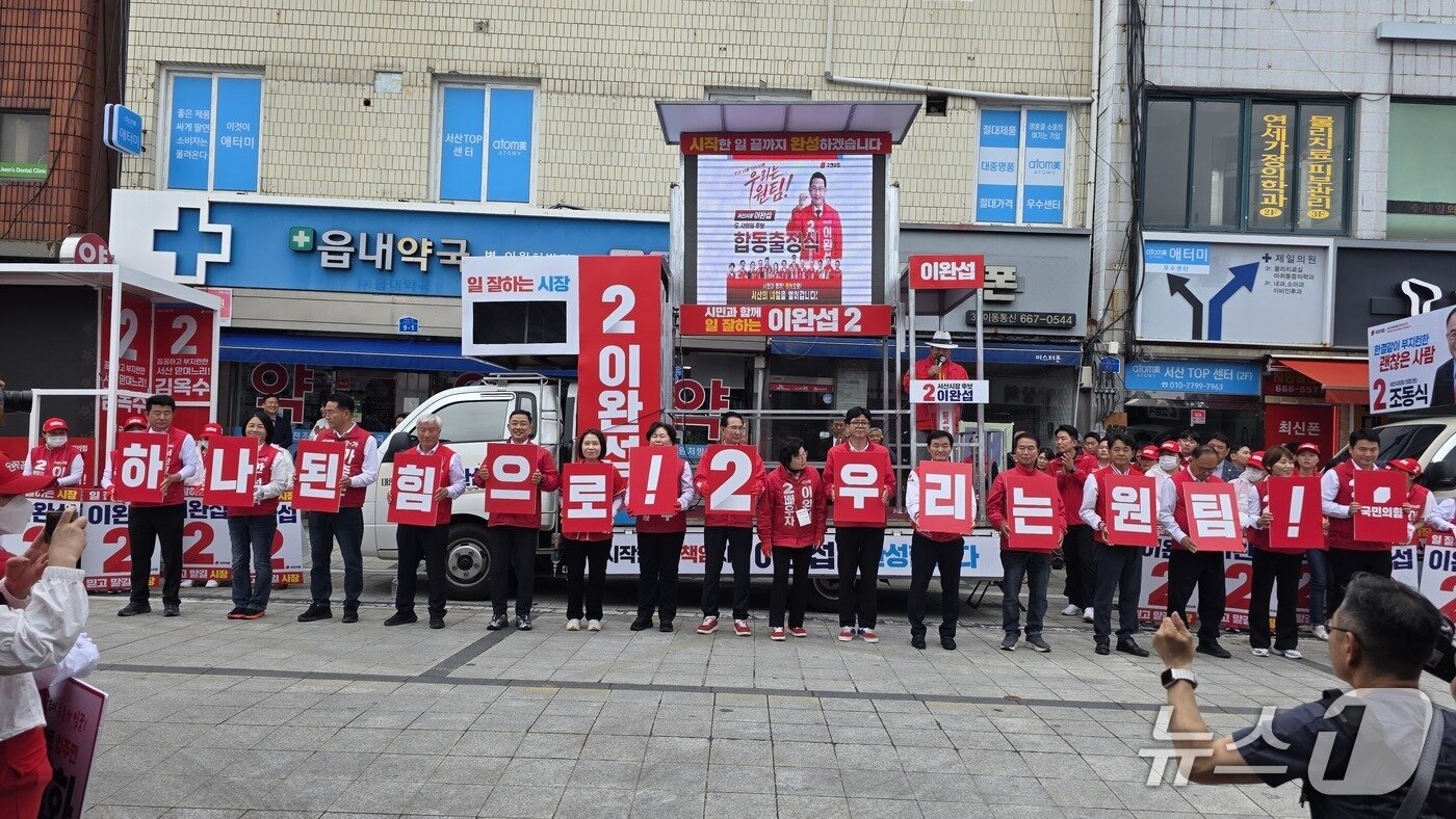 본문 이미지 - 이완섭 서산시장 후보와 도의원·시의원 후보들이 ‘하나 된 힘으로 2 우리는 원팀’ 퍼포먼스를 선보이며 승리를 다짐했다.(제공. 재판매 및 DB금지)2026.5.21 ⓒ 뉴스1 김태완 기자