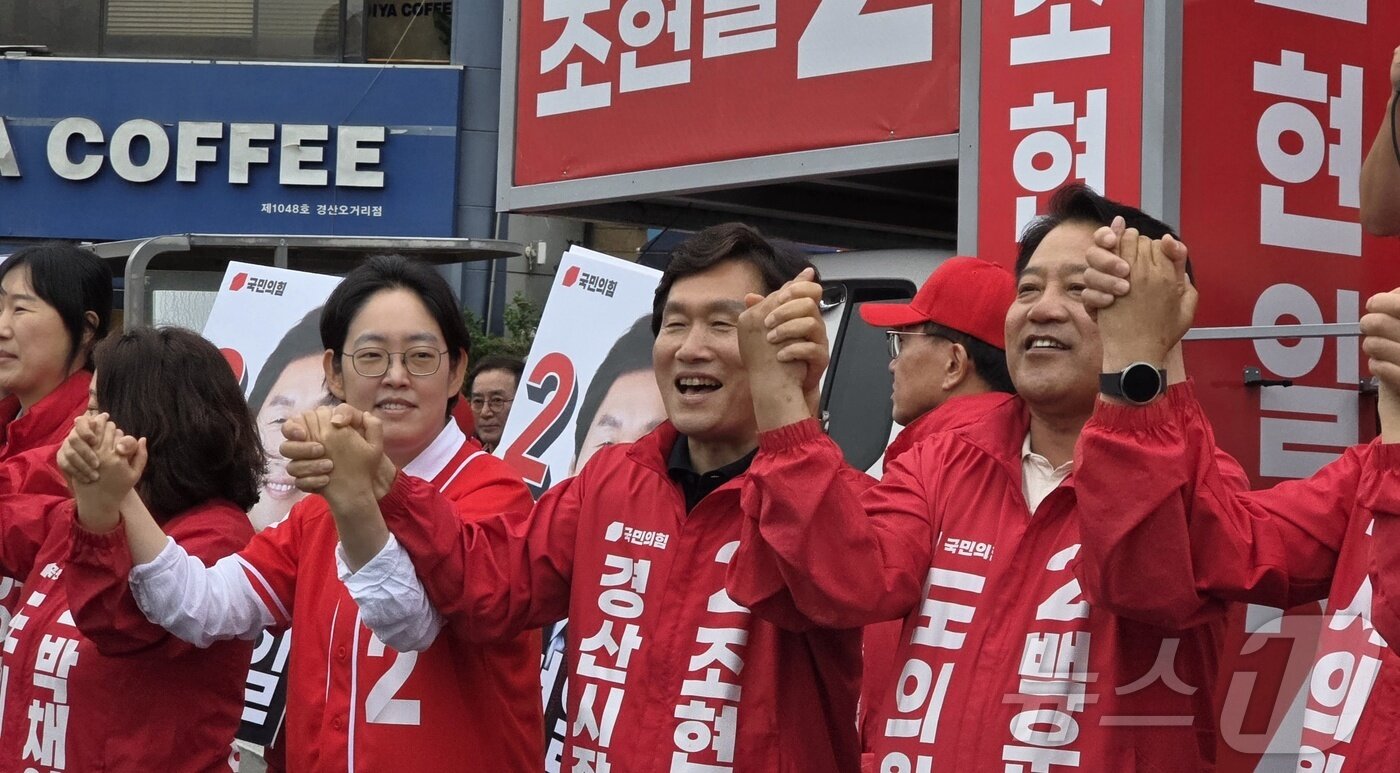 본문 이미지 - 조현일 국민의힘 경산시장 후보(가운데)가 21일 경산오거리에서 열린 출정식에서 국민의힘 조지연 의원과 손을 들고 화이팅을 외치고 있다. (재판매 및 DB금지) ⓒ 뉴스1 정우용 기자