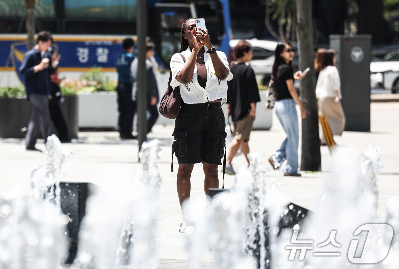 (서울=뉴스1) 임지훈 인턴기자 = 낮 최고 기온이 27도까지 오르는 등 초여름 날씨를 보인 22일 오후 서울 종로구 광화문광장 바닥 분수를 찾은 외국인 관광객이 사진을 찍고 있다 …