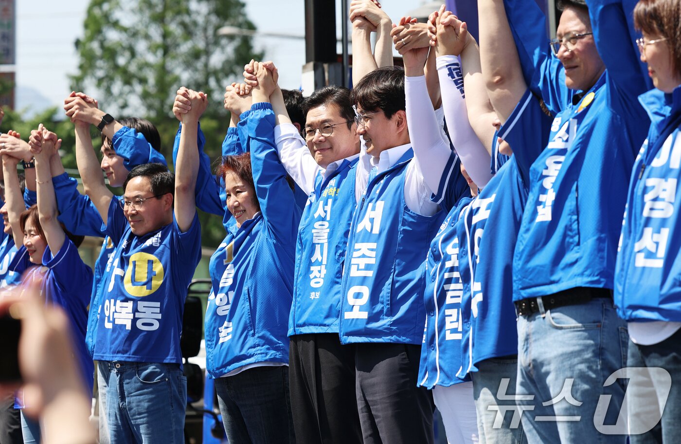 본문 이미지 - 정원오 더불어민주당 서울시장 후보가 22일 오후 서울 노원구 롯데백화점 앞에서 열린 집중유세에서 노원지역 출마자들과 손을 맞잡은 채 지지를 호소하고 있다. 2026.5.22 ⓒ 뉴스1 오대일 기자