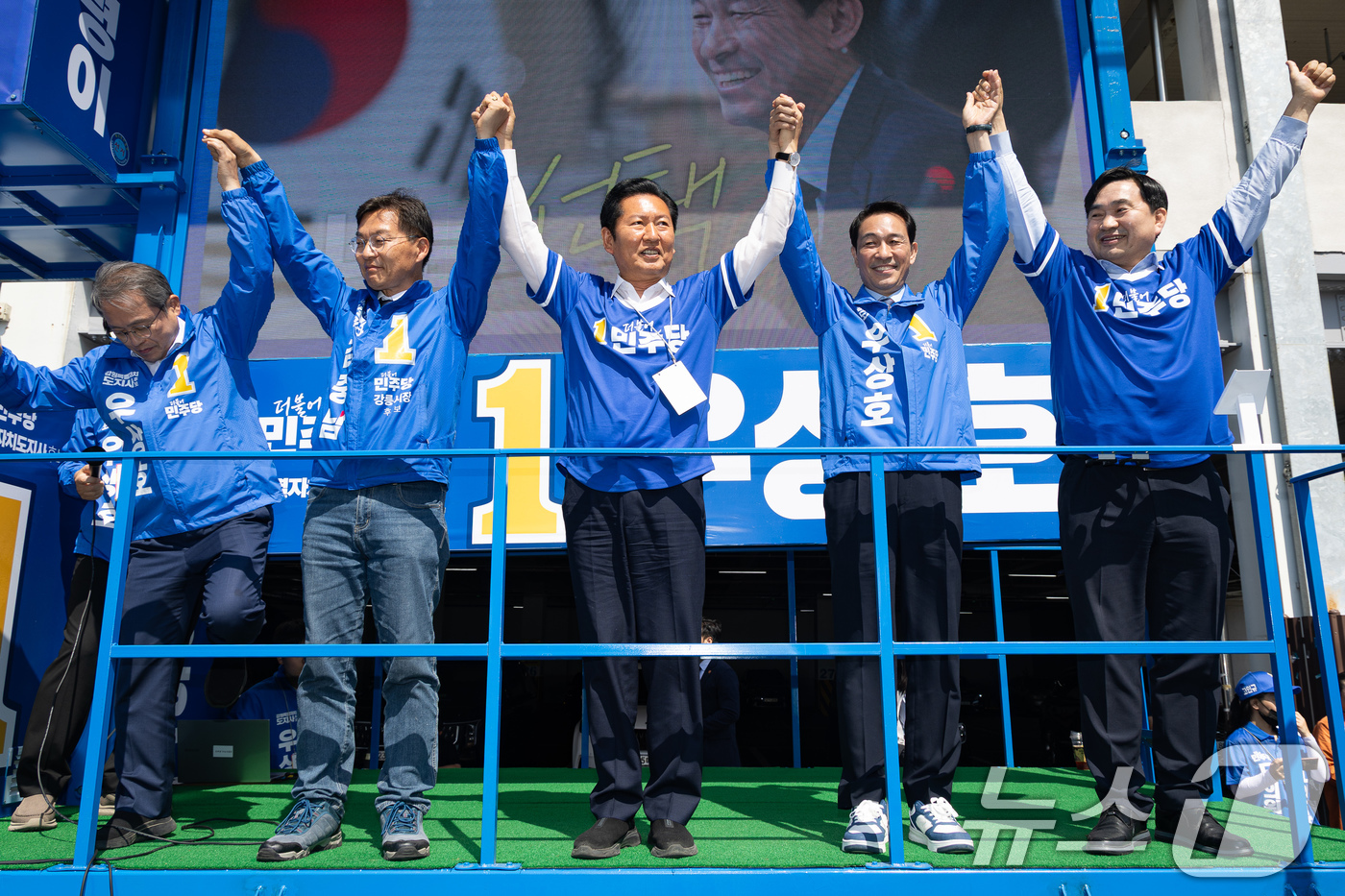 (강릉=뉴스1) 유승관 기자 = 정청래 더불어민주당 대표와 우상호 강원특별자치도지사 후보, 김중남 강릉시장 후보가 22일 강원 강릉시 주문진 시장 앞에서 손을 맞잡고 시민들을 향해 …