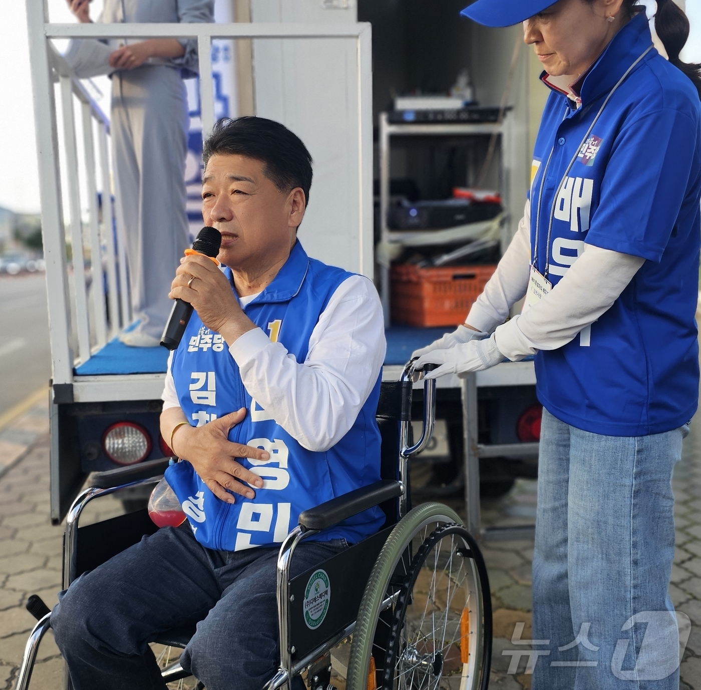 (김천=뉴스1) 정우용 기자 = 나영민 더불어민주당 김천시장 후보가 22일 경북 김천시 평화동 맥도날드 사거리에서 열린 합동유세에서 부인 이경선씨의 도움을 받아 휠체어를 탄 채 선 …