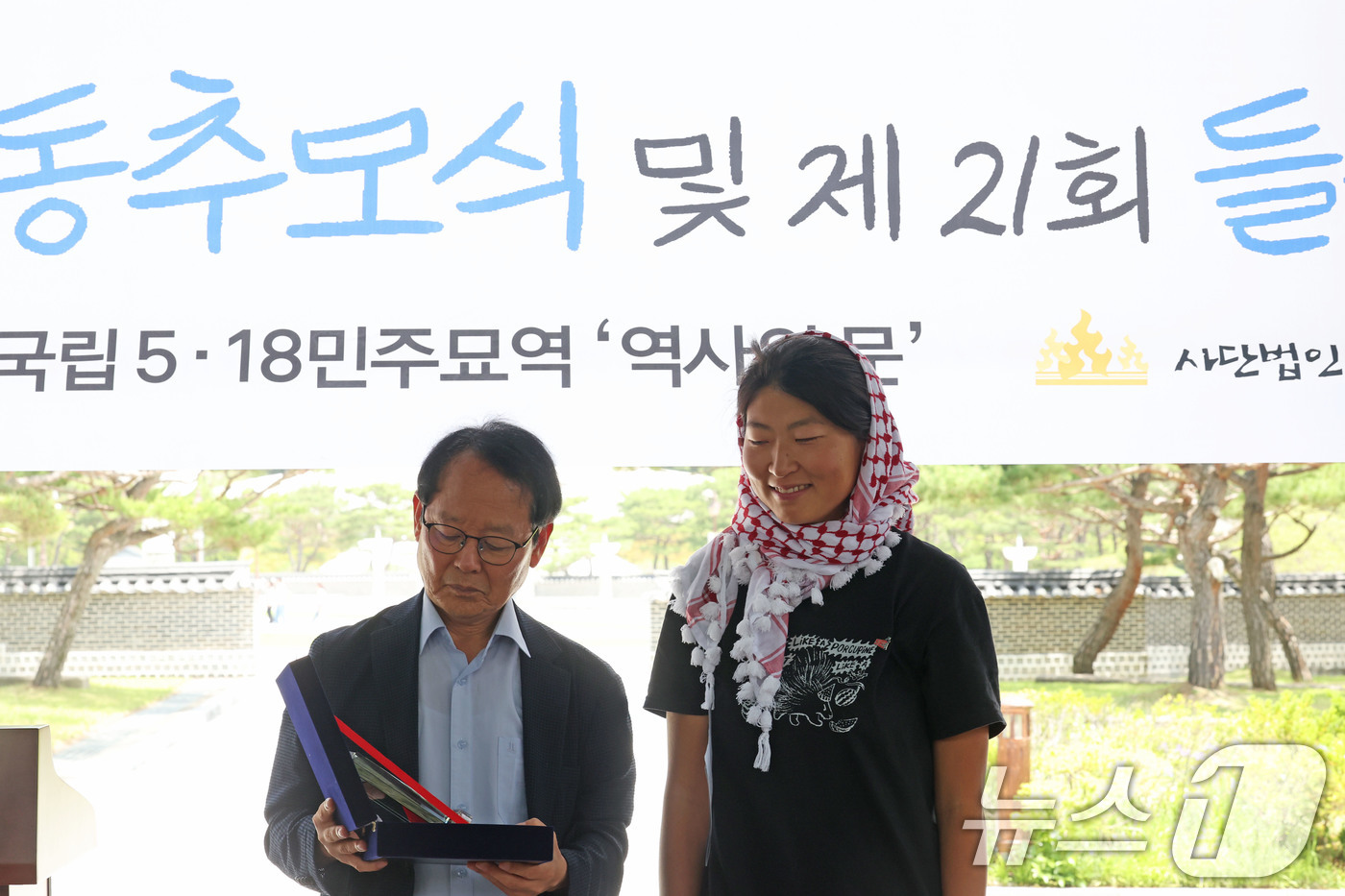(광주=뉴스1) 박지현 기자 = 23일 오전 광주 북구 운정동에 위치한 국립 5·18민주묘지 역사의문 앞에서 김아현 씨(활동명 해초)가  제21회 들불상을 수여받고 있다. 김 활동 …