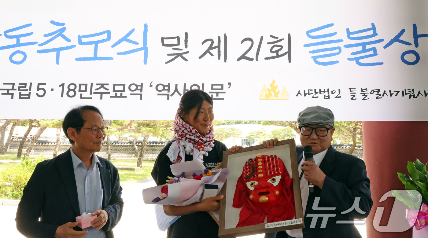 (광주=뉴스1) 박지현 기자 = 23일 오전 광주 북구 운정동에 위치한 국립 5·18민주묘지 역사의문 앞에서 김아현 씨(활동명 해초)가  제21회 들불상을 수여받고 있다. 김 활동 …