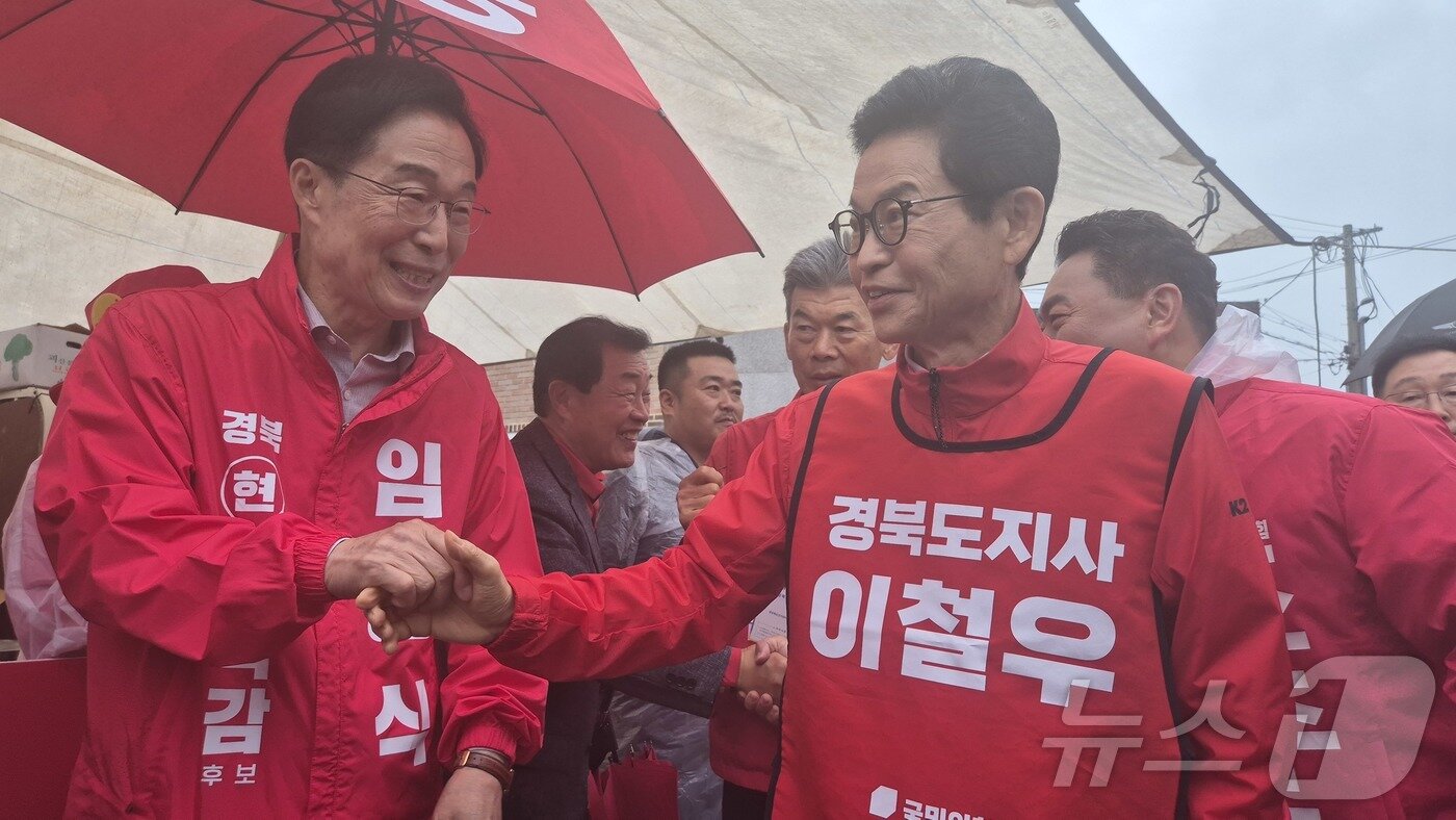 본문 이미지 - 23일 오전 영덕시장에서 열린 국민의힘 영덕군 후보 합동 출정식에서 이철우 경북도지사 후보와 친구인 임종식 경북교육감 후보가 시장에서 만나 악수를 나누고 있다. 2026.5.23 ⓒ 뉴스1 김대벽기자