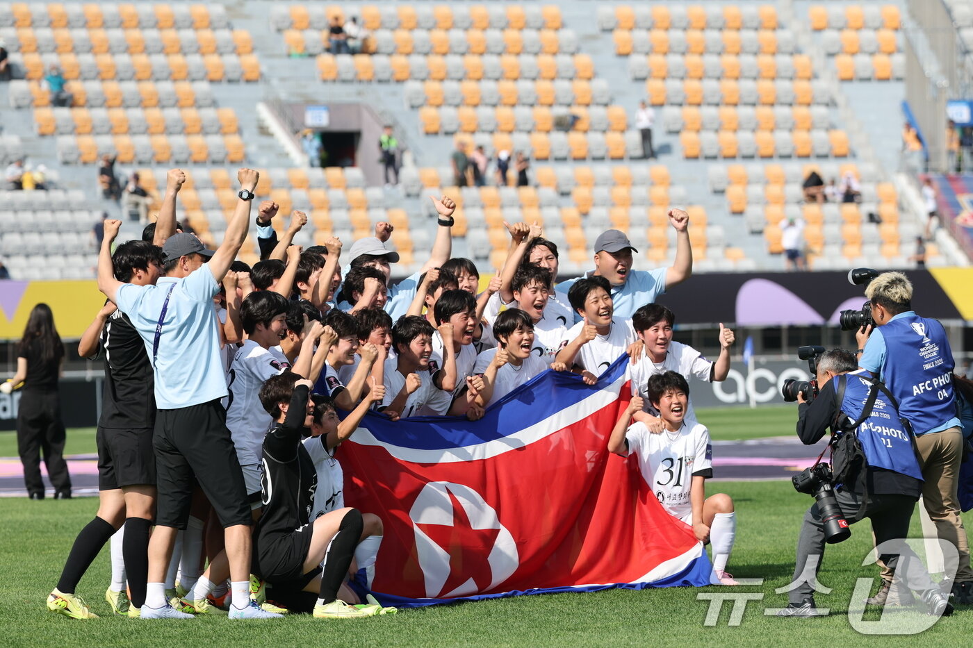 본문 이미지 - 23일 오후 경기 수원시 수원종합운동장에서 열린 2025-2026 아시아축구연맹(AFC) 여자 챔피언스리그(AWCL) 결승 도쿄 베르디의 경기에서 1-0으로 승리하며 사상 첫 정상에 오른 내고향여자축구단 선수들이 인공기를 들고 기념촬영을 하고 있다. 2026.5.23 ⓒ 뉴스1 박지혜 기자