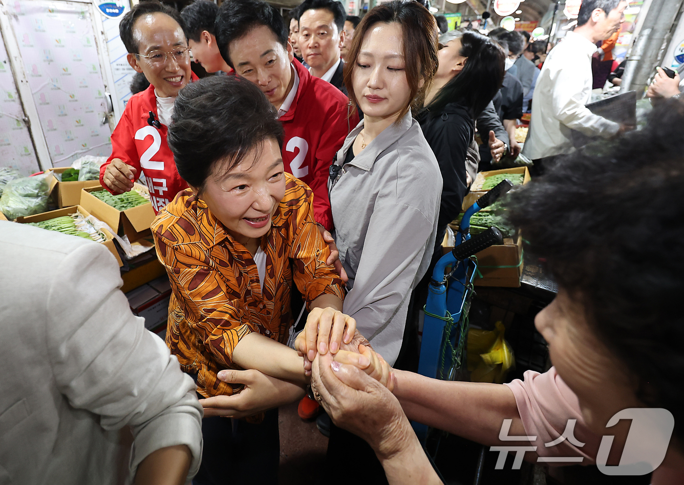 (대구=뉴스1) 공정식 기자 = 박근혜 전 대통령이 23일 오후 대구 북구 칠성시장을 찾아 추경호 국민의힘 대구시장 후보 등 일행과 함께 시장으로 이동하며 상인과 인사 나누고 있다 …