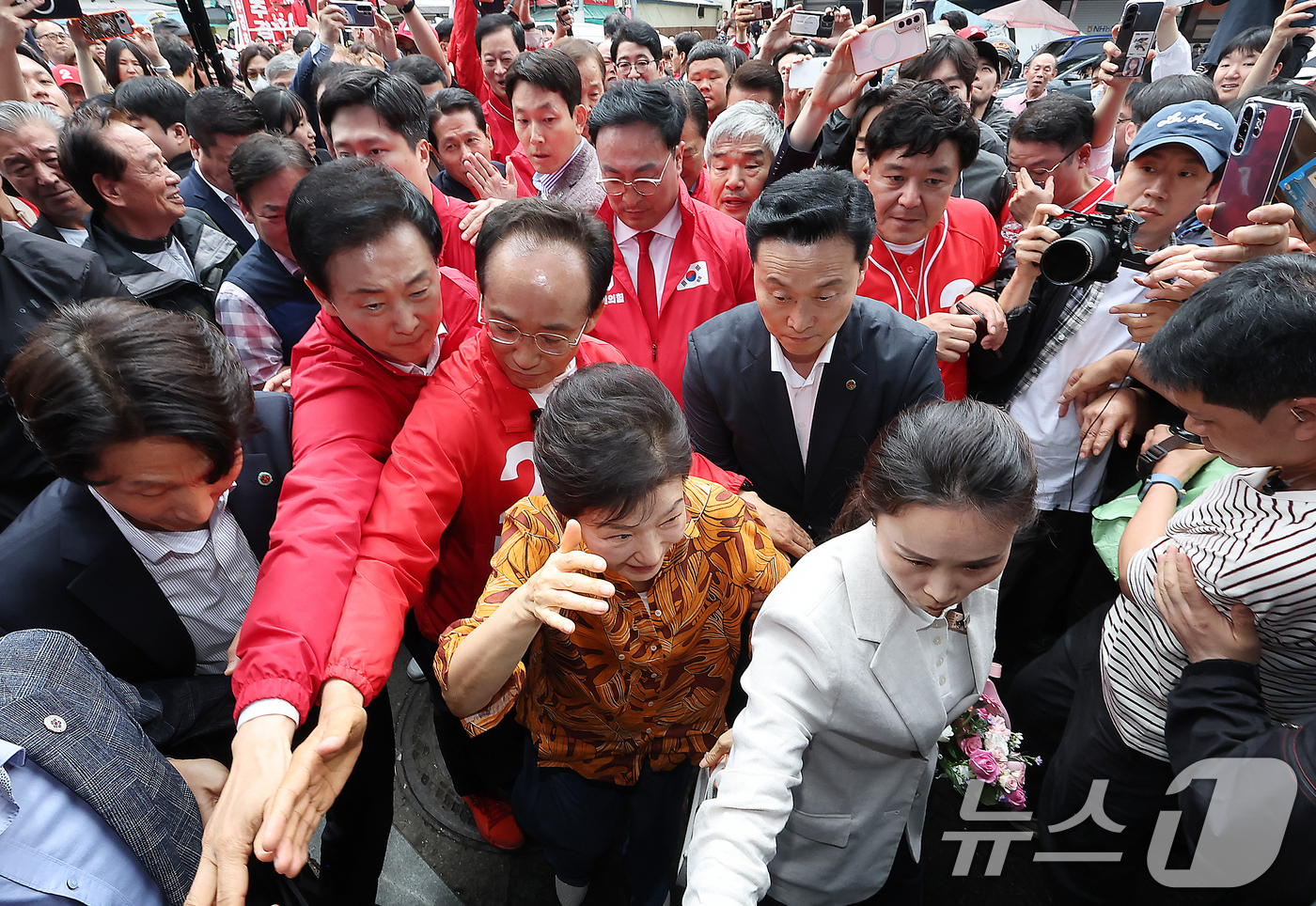 (대구=뉴스1) 공정식 기자 = 박근혜 전 대통령이 23일 오후 대구 북구 칠성시장을 찾아 추경호 대구시장 후보 등 일행과 함께 시장으로 이동하고 있다. 2026.5.23/뉴스1