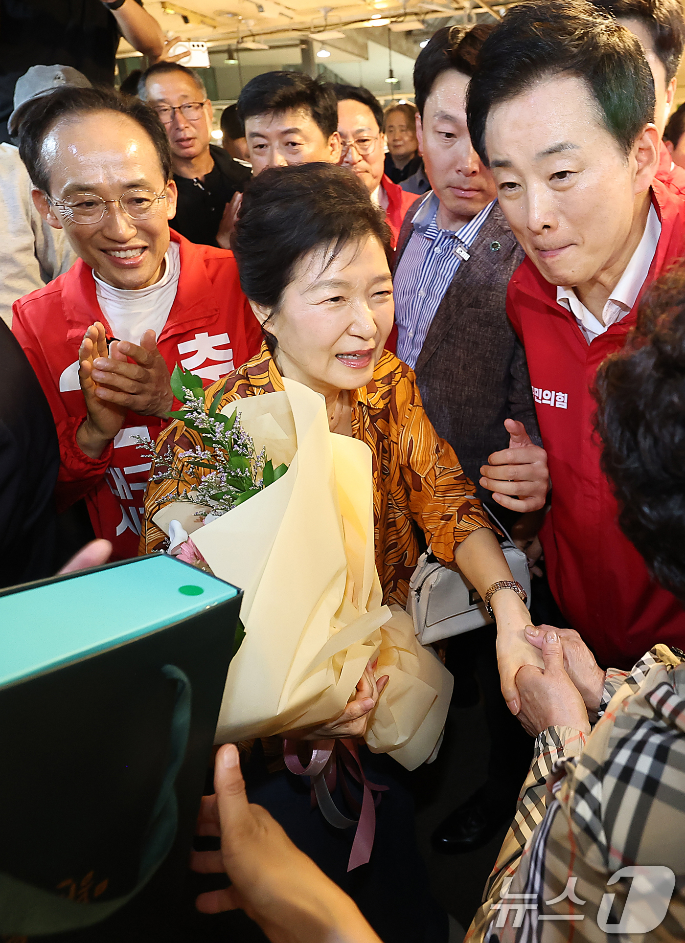 (대구=뉴스1) 공정식 기자 = 박근혜 전 대통령이 23일 오후 대구 북구 칠성시장을 찾아 추경호 국민의힘 대구시장 후보 등 일행과 함께 시장으로 이동하며 상인과 인사 나누고 있다 …