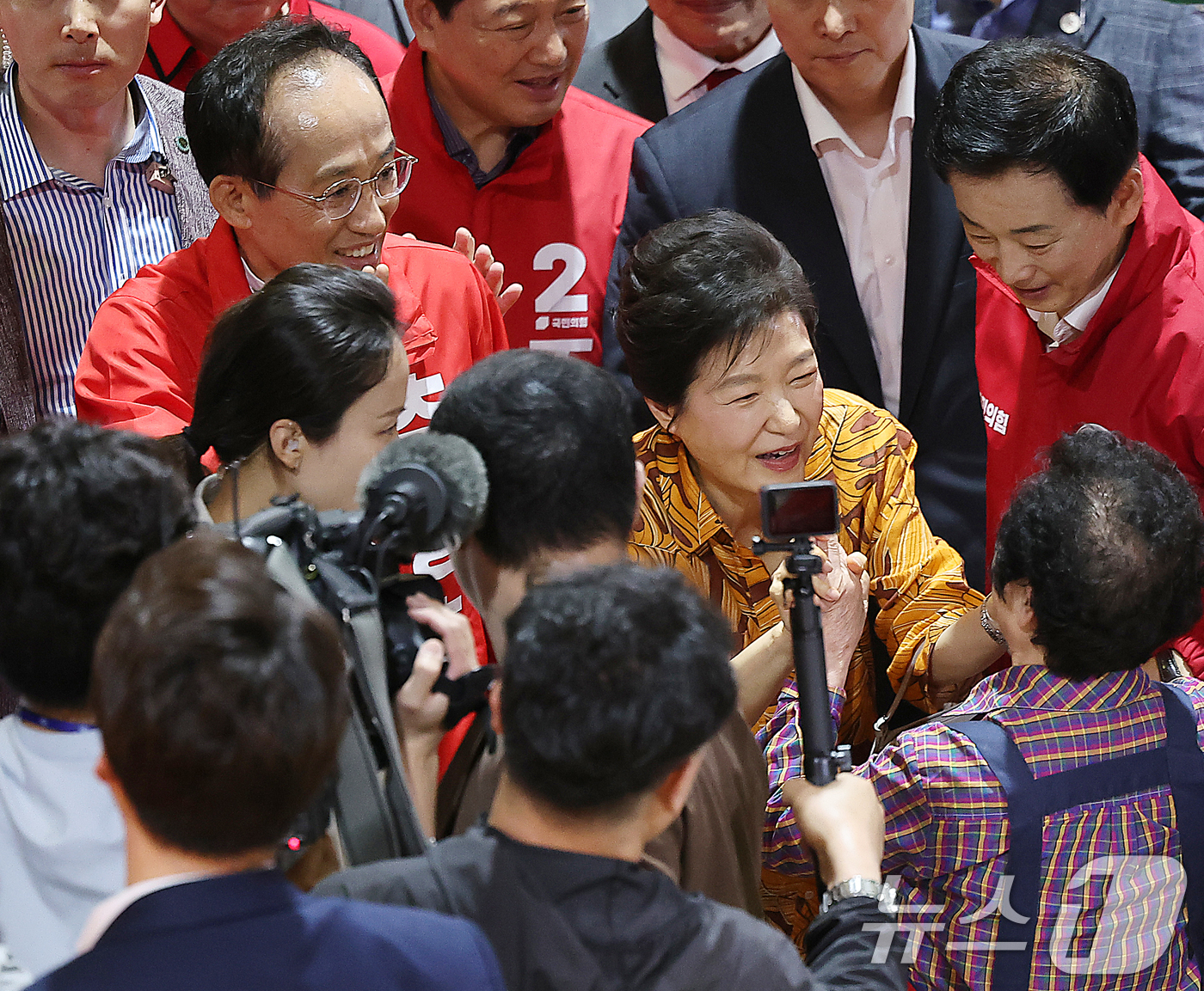 (대구=뉴스1) 공정식 기자 = 박근혜 전 대통령이 23일 오후 대구 북구 칠성시장을 찾아 추경호 국민의힘 대구시장 후보 등 일행과 함께 이동하며 상인과 인사 나누고 있다. 202 …