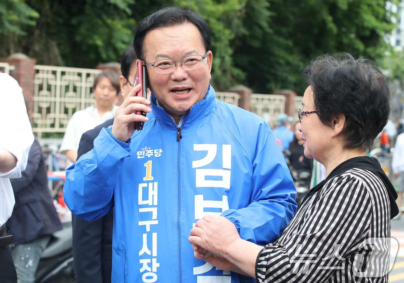 (대구=뉴스1) 공정식 기자 = 김부겸 더불어민주당 대구시장 후보가 23일 오전 대구 중구 달성공원 새벽시장을 찾아 한 시민의 요청에 휴대전화로 통화하고 있다. 2026.5.23/ …