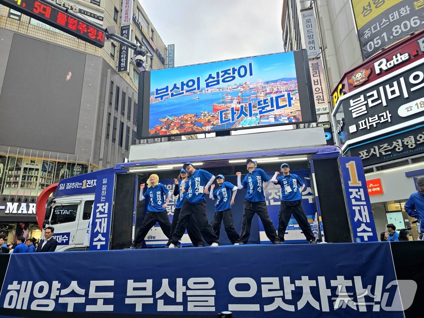 본문 이미지 - 23일 부산진구 서면에서 전재수 후보 선거캠프 소속 선거운동원들이 선거송에 맞춰 춤을 추고 있다. 2026.5.23 ⓒ 뉴스1 이주현 기자