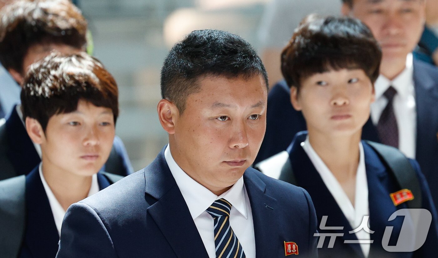 본문 이미지 - 북한 내고향여자축구단 리유일 감독과 김경영, 김혜영이 24일 오후 인천국제공항 1터미널에서 중국 베이징으로 출국하기 위해 이동하고 있다. 내고향축구단은 2025-2026 아시아축구연맹(AFC) 여자 챔피언스리그(AWCL) 결승 도쿄 베르디와의 경기에서 1-0으로 승리해 사상 처음으로 아시아 정상에 올랐다. 2026.5.24 ⓒ 뉴스1 안은나 기자