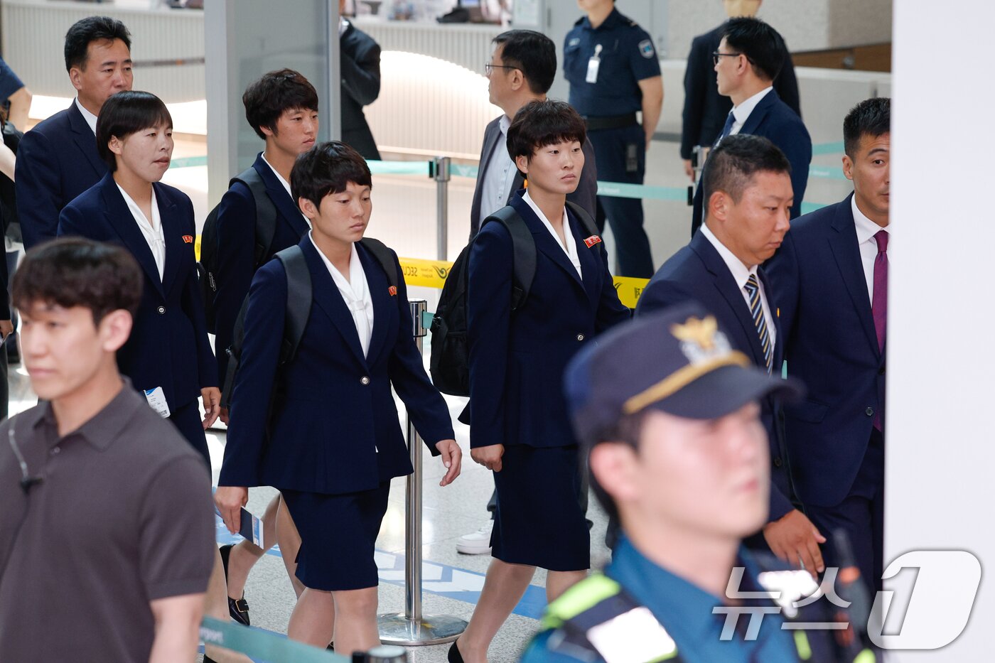 본문 이미지 - 북한 내고향여자축구단 리유일 감독과 김경영, 김혜영 등 선수들이 24일 오후 인천국제공항 1터미널에서 중국 베이징으로 출국하기 위해 이동하고 있다. 내고향축구단은 2025-2026 아시아축구연맹(AFC) 여자 챔피언스리그(AWCL) 결승 도쿄 베르디와의 경기에서 1-0으로 승리해 사상 처음으로 아시아 정상에 올랐다. 2026.5.24 ⓒ 뉴스1 안은나 기자