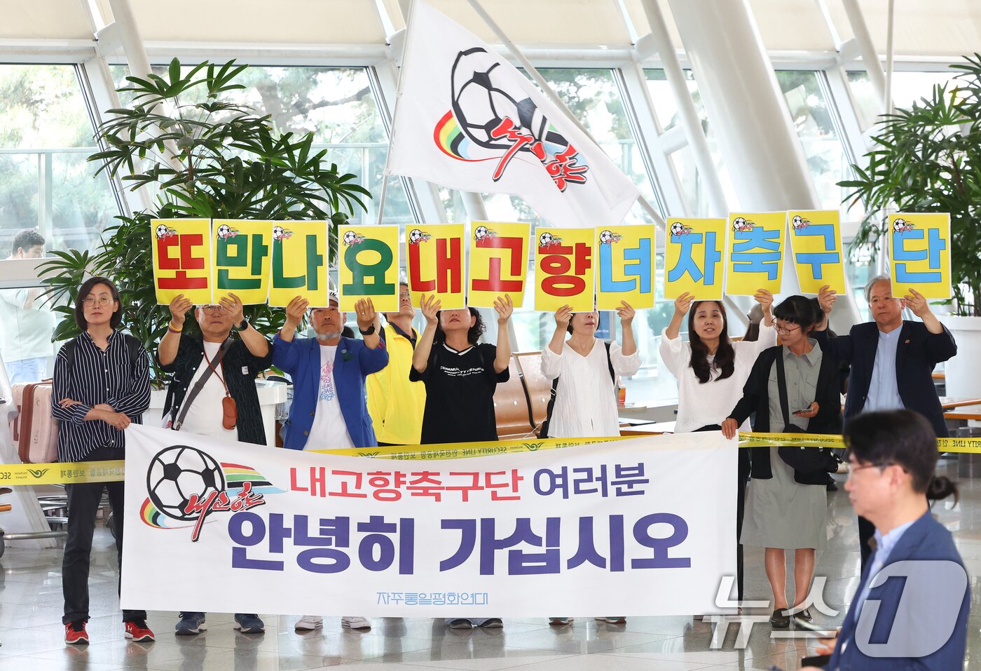 본문 이미지 - 자주통일평화연대 회원들이 24일 오후 인천국제공항 1터미널에서 2025~2026시즌 아시아축구연맹(AFC) 여자 챔피언스리그(AWCL) 출전을 위해 방남했던 북한 내고향여자축구단 선수들을 배웅하고 있다. (공동취재) ⓒ 뉴스1 안은나 기자