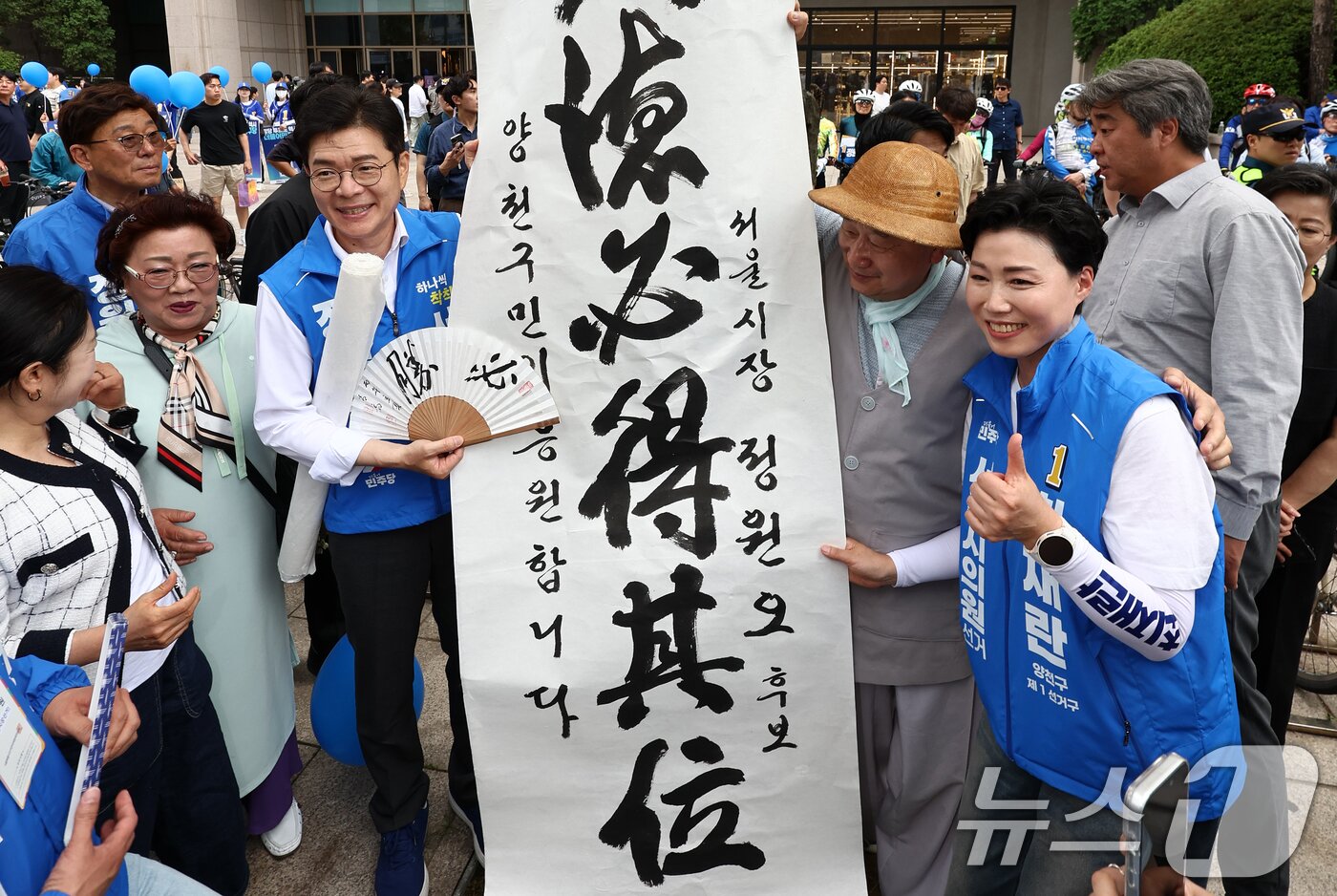 본문 이미지 - 정원오 더불어민주당 서울시장 후보가 25일 오후 서울 양천구 현대백화점 목동점 앞 유세 현장에서 지지자에게 응원 선물을 받고 있다. 2026.5.25 ⓒ 뉴스1 최지환 기자