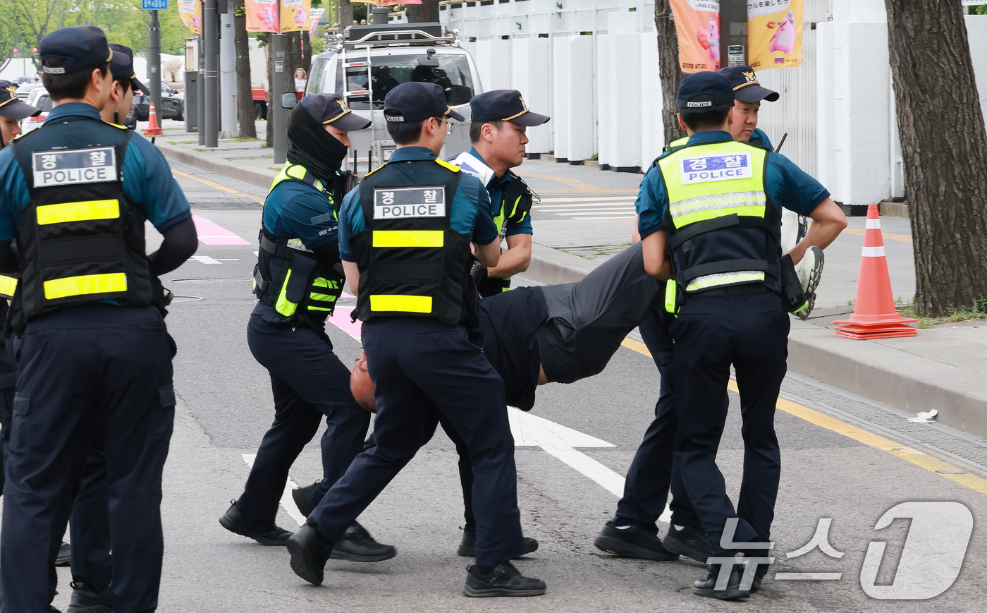 (서울=뉴스1) 임세영 기자 = 홈플러스 노조원들이 25일 오후 서울 종로구 정부서울청사 인근에서 대통령 면담을 요구하며 도로에 누워, 경찰에 끌려나가고 있다.  2026.5.25 …