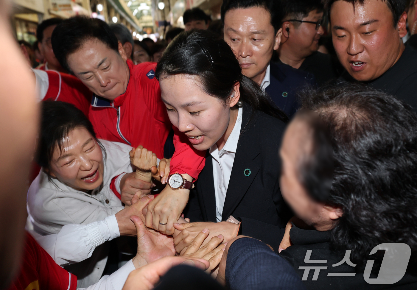 (공주=뉴스1) 김기태 기자 = 박근혜 전 대통령이 25일 오후 충남 공주 산성시장을 방문해 김태흠 국민의힘 충남도지사 후보, 충남지역 후보 지원유세중 시민이 손을 잡아채 고틍스러 …