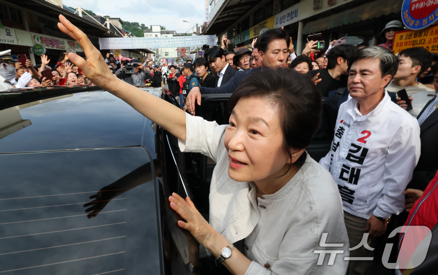 (공주=뉴스1) 김기태 기자 = 박근혜 전 대통령이 25일 오후 충남 공주 산성시장을 방문해 김태흠 국민의힘 충남도지사 후보, 충남지역 후보 지원유세를 마치고 시민들에게 인사하고 …