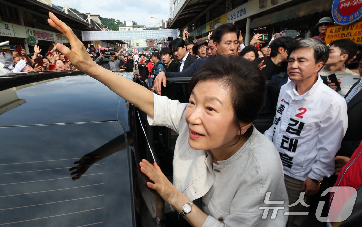 본문 이미지 - 박근혜 전 대통령이 25일 오후 충남 공주 산성시장을 방문해 김태흠 국민의힘 충남도지사 후보, 충남지역 후보 지원유세를 마치고 시민들에게 인사하고 있다. 2026.5.25 ⓒ 뉴스1 김기태 기자