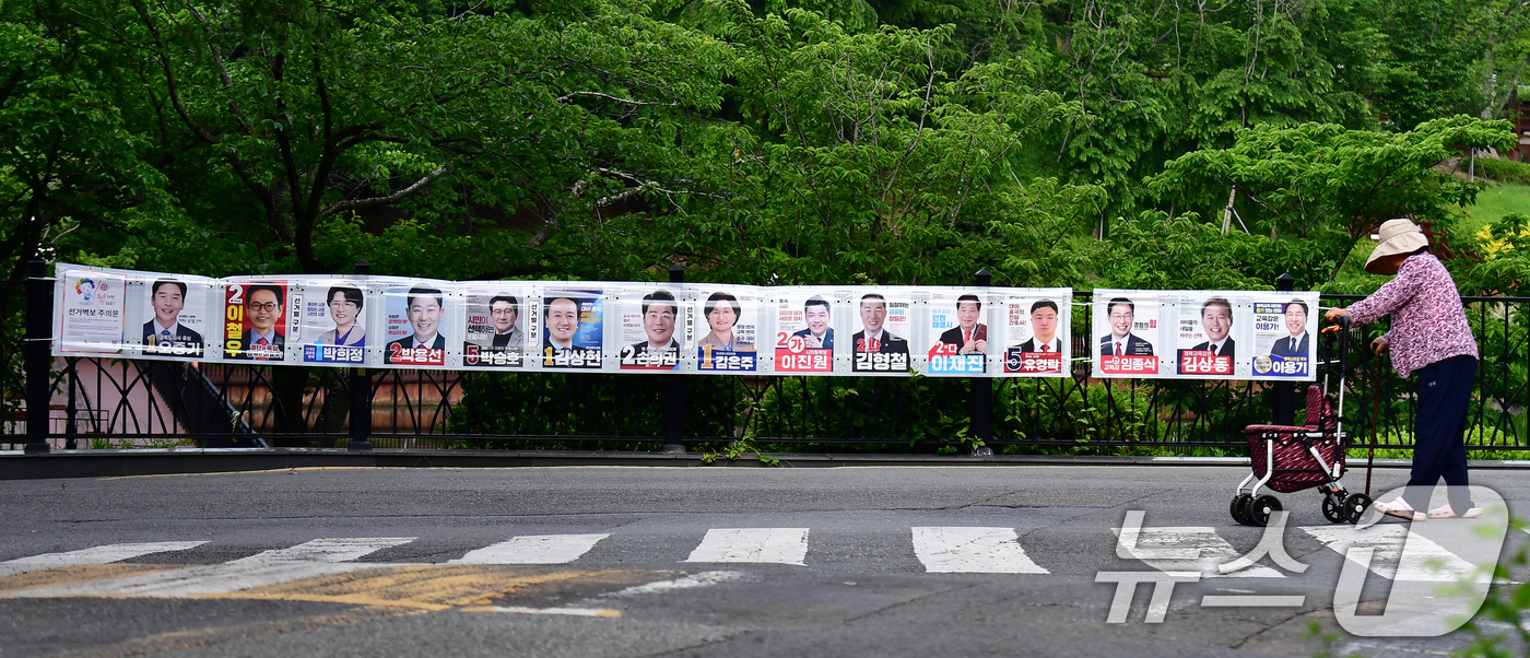 (포항=뉴스1) 최창호 기자 = 6·3전국동시지방선거 사전투표일(29일)을 사흘 앞둔 26일 경북 포항시 남구 대잠동 영일대호수공원에 걸려있는 선거 벽보 앞으로 시민이 지나가고 있 …