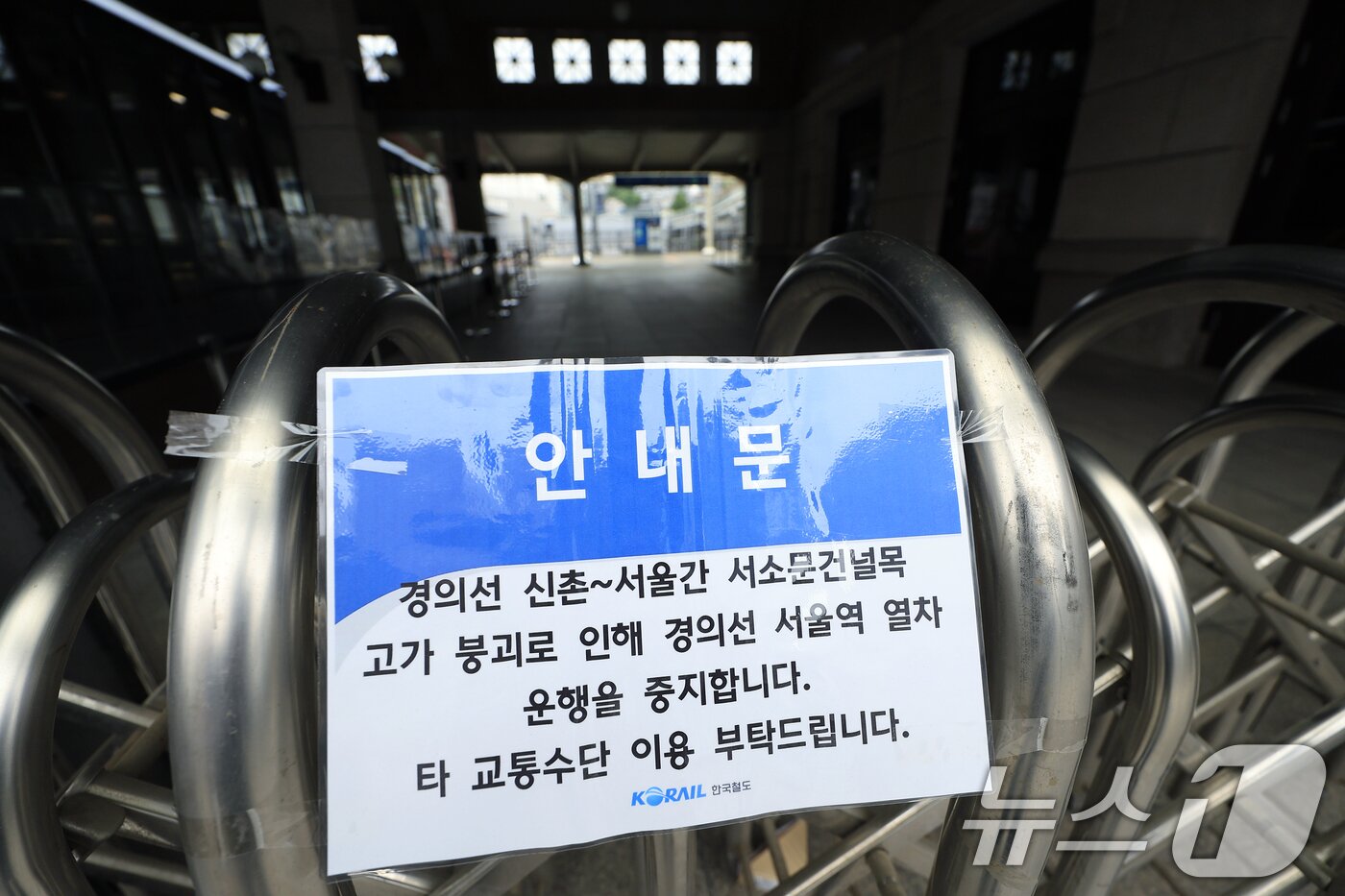 본문 이미지 - 서소문 고가차도 붕괴 사고 여파로 KTX와 일반열차 운행이 대거 중단·조정된 27일 오전 서울 용산구 한강대로 서울역 경의선 출입구 앞 굳게 닫힌 철제 바리게이트에 열차 운행 주지 안내문이 붙어 있다.  2026.5.27 ⓒ 뉴스1 박정호 기자