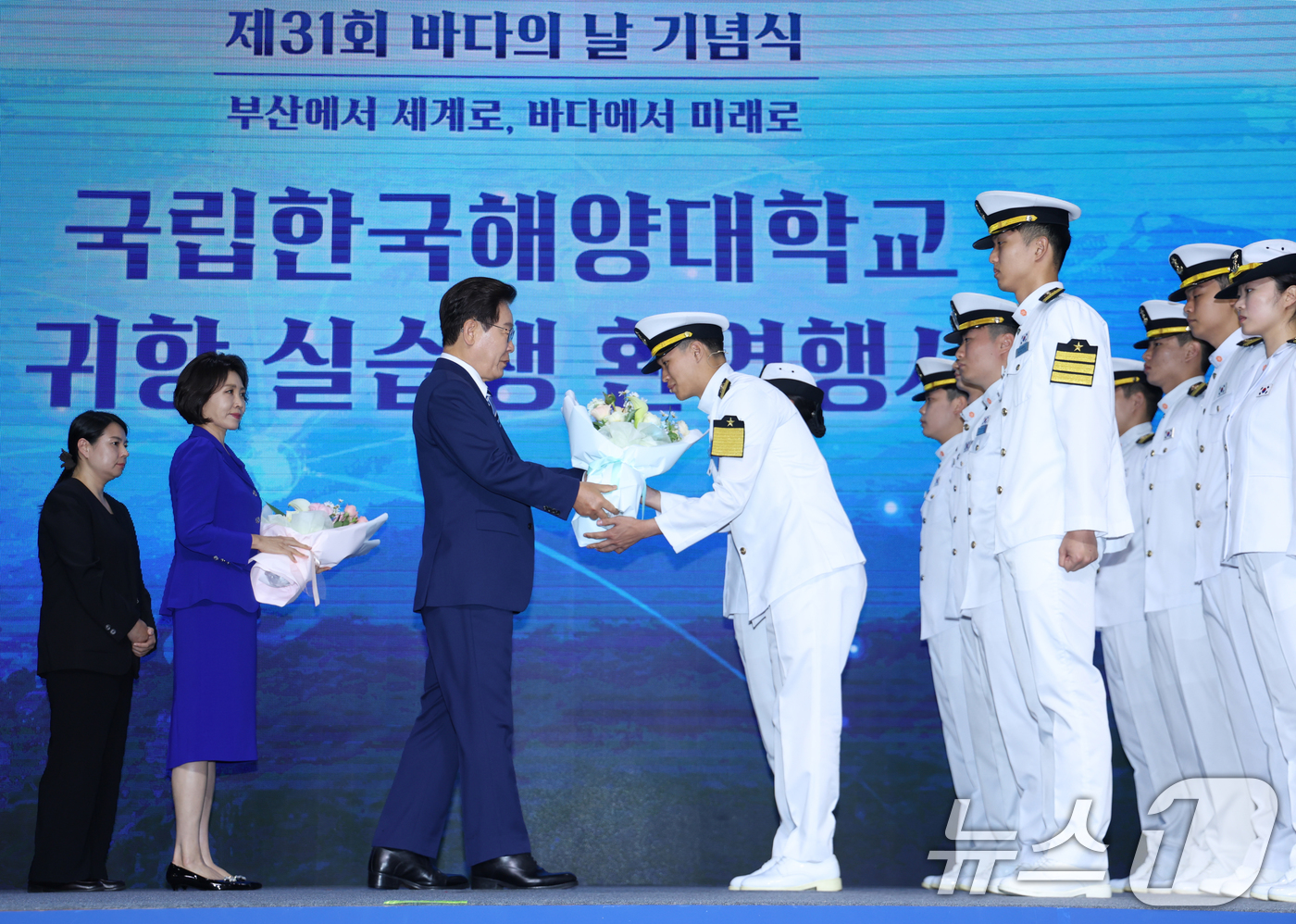 (부산=뉴스1) 허경 기자 = 이재명 대통령이 27일 부산 영도구에서 열린 제31회 바다의날 기념식에서 해양대 실습생들의 귀항 보고를 받는 뒤 꽃다발을 전달하고 있다. (청와대통신 …