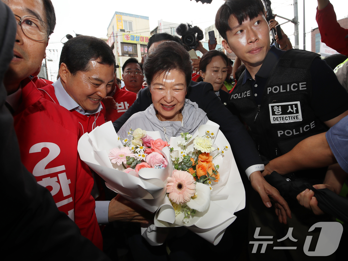 (진주=뉴스1) 윤일지 기자 = 박근혜 전 대통령이 27일 경남 진주 대안동 진주중앙시장을 찾아 꽃다발을 받고 있다.  2026.5.27/뉴스1