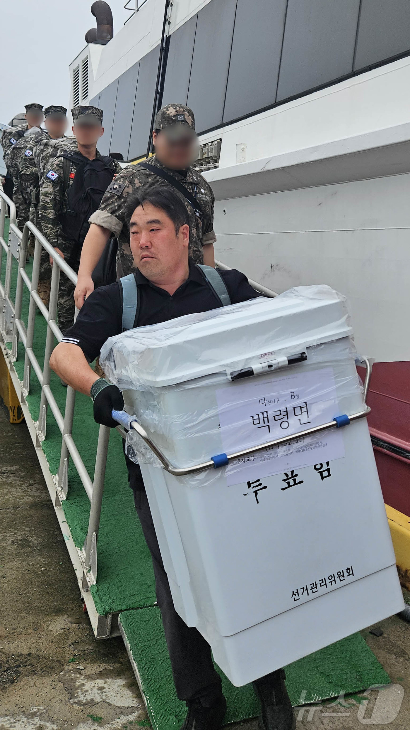 (서울=뉴스1) = 제9회 전국동시지방선거를 7일 앞둔 27일 인천선거관리위원회 관계자가 인천 백령도에 투표함을 들고 배에서 내리고 있다. (한국해양교통안전공단 인천항운항관리센터 …