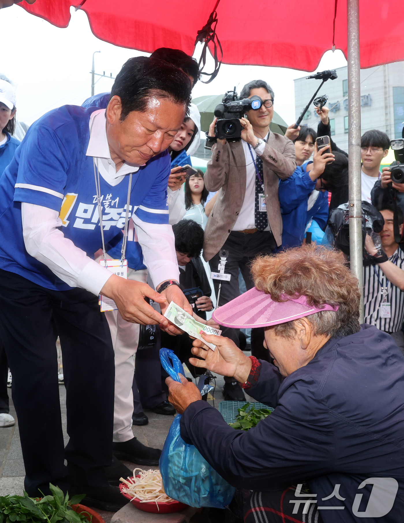 (인천=뉴스1) 황기선 기자 = 정청래 더불어민주당 대표가 27일 오후 인천 강화군 강화풍물시장에서 농산물을 구입하고 있다.  2026.5.27/뉴스1