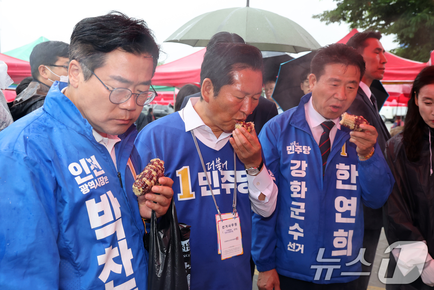 (인천=뉴스1) 황기선 기자 = 더불어민주당 정청래 대표와 박찬대 인천시장 후보가 27일 오후 인천 강화군 강화풍물시장에서 구입한 옥수수를 먹고 있다.  2026.5.27/뉴스1