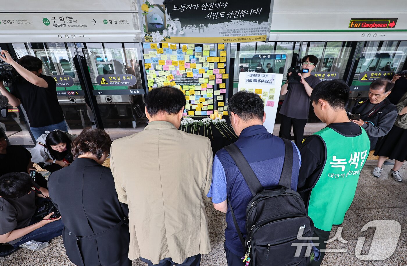본문 이미지 - 28일 서울 광진구 지하철 2호선 구의역에서 열린 '구의역 참사' 10주기 시민추모식 참석자들이 헌화 및 묵념을 하고 있다. 2026.5.28 ⓒ 뉴스1 김도우 기자