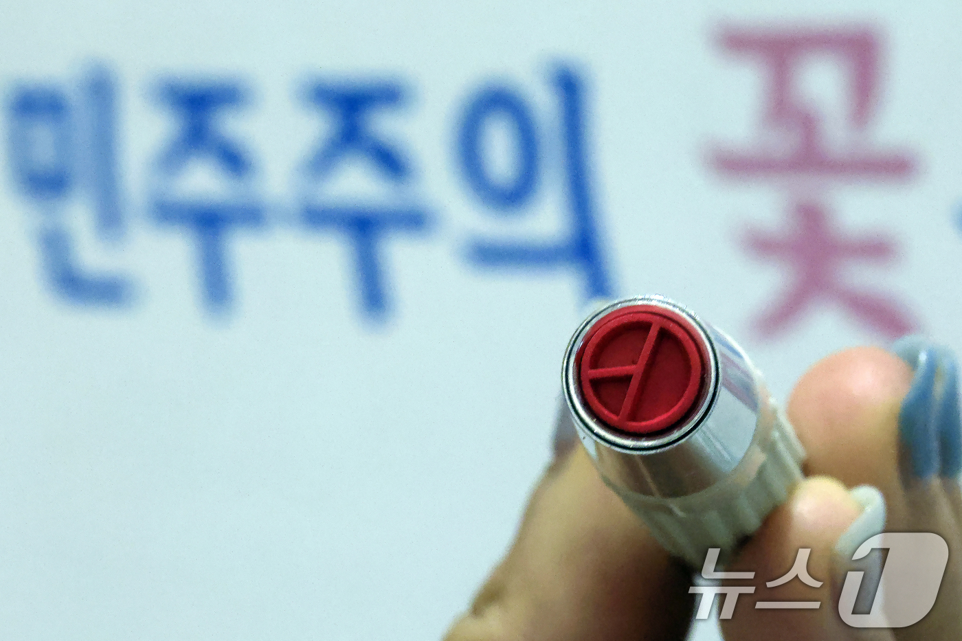 (서울=뉴스1) 박정호 기자 = 제9회 전국동시지방선거 사전투표일을 하루 앞둔 28일 오후 서울시 종로구 신문로 사직동주민센터에 설치된 사전투표소에서 선거사무원이 기표용구를 들어 …