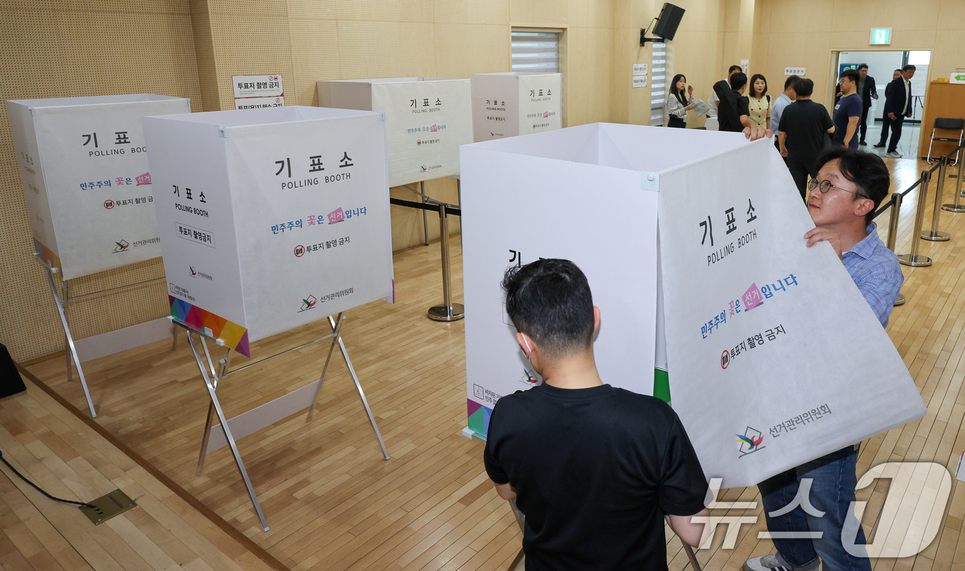 (서울=뉴스1) 안은나 기자 = 제9회 전국동시지방선거 사전투표를 하루 앞둔 28일 오후 서울 종로구 종로1·2·3·4가동주민센터에 마련된 사전투표소에서 관계자들이 기표소를 점검하 …