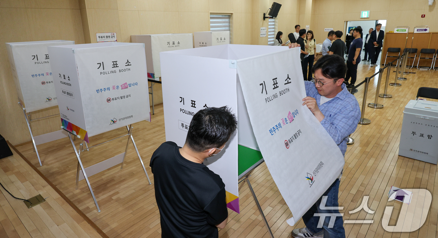 (서울=뉴스1) 안은나 기자 = 제9회 전국동시지방선거 사전투표를 하루 앞둔 28일 오후 서울 종로구 종로 1234가동주민센터에 마련된 사전투표소에서 관계자들이 기표소를 점검하고 …