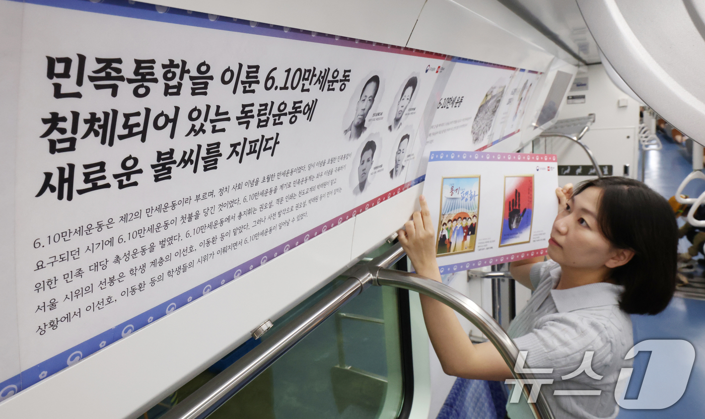 (수원=뉴스1) 김영운 기자 = 28일 경기 수원시 영통구 신분당선 광교차량기지에서 경기동부보훈지청 관계자들이 열차 내부에 독립호국정신을 주제로 한 다양한 콘텐츠를 부착하고 있다. …