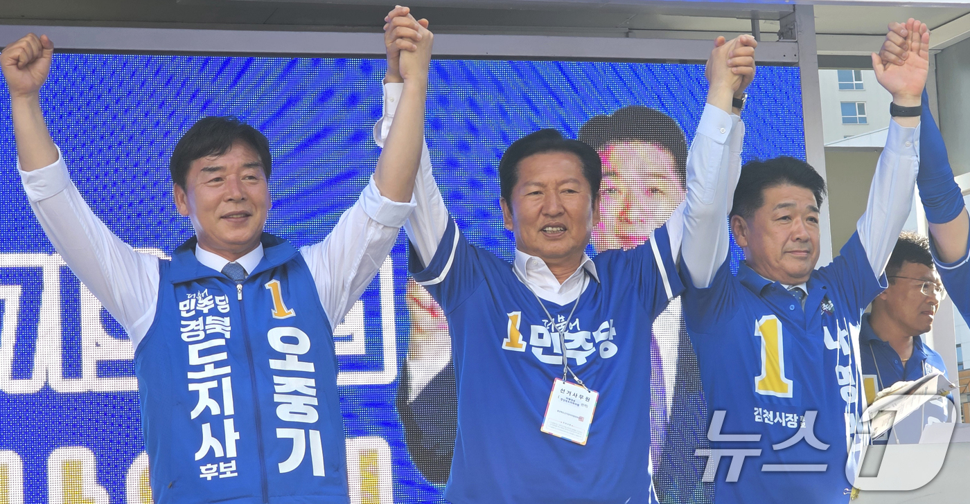 (김천=뉴스1) 정우용 기자 = 정청래 더불어민주당 대표가 28일 오후 경북 김천시 혁신도시에서 열린 합동유세에서 오중기 경북지사 후보(왼쪽)와 나영민 김천시장 후보의 손을 잡고 …