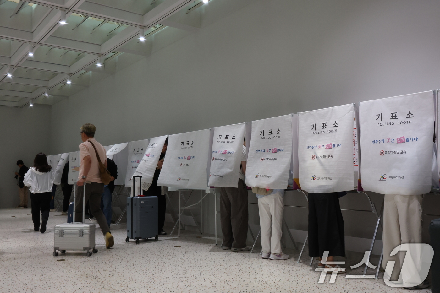 (인천공항=뉴스1) 김진환 기자 = 6·3지방선거 사전투표가 시작된 29일 오전 인천국제공항 제1터미널 출국장에 설치된 사전투표소에서 시민들이 출국 전 사전투표를 하고 있다. 20 …